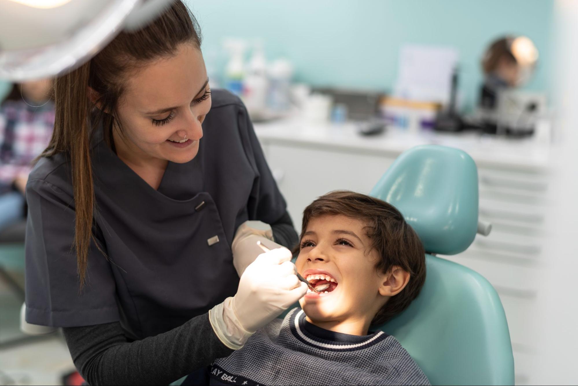 Child receiving orthodontic evaluation from dental professional at Viva Orthodontics in Bountiful, highlighting early treatment benefits and clear aligners options.